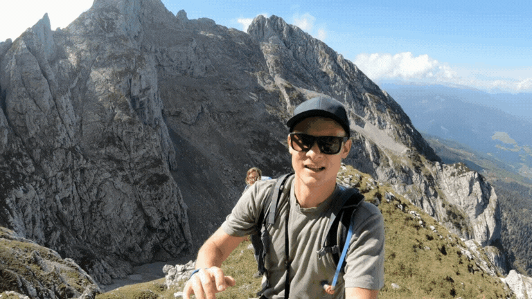 Man using his arm to show off a beautiful mountain range