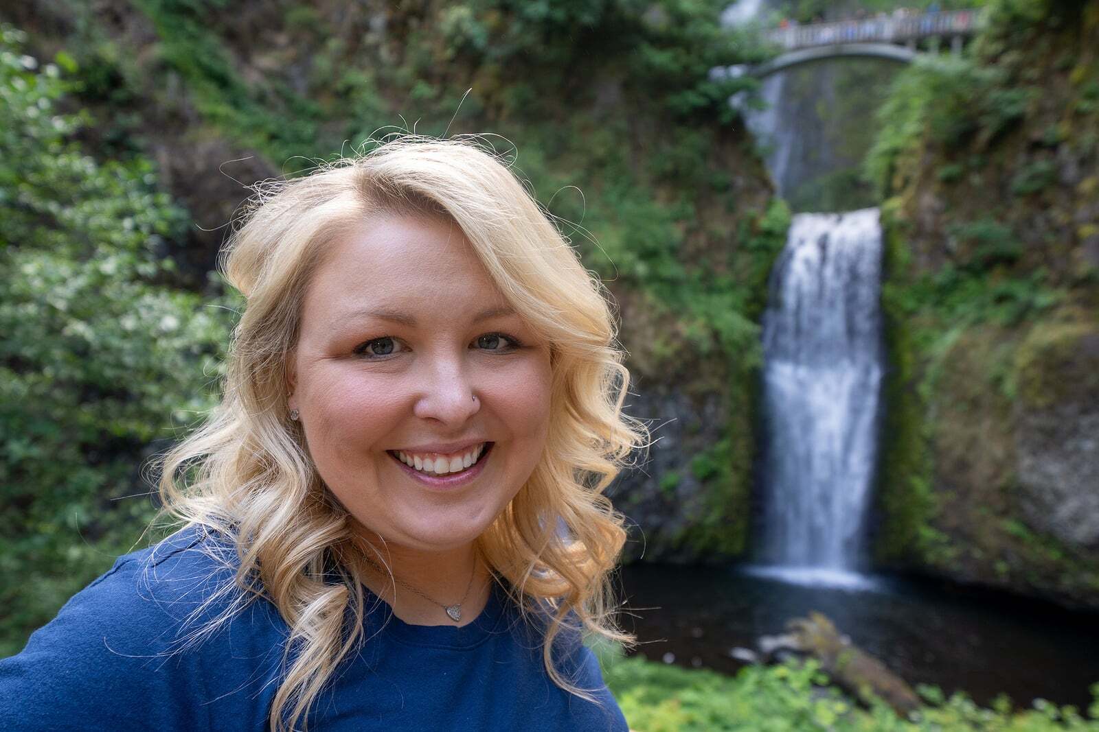 Woman taking a selfie in front of a waterfall