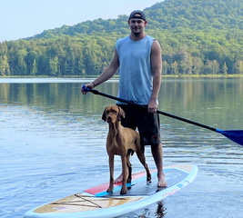 Man on a paddle board with his dog
