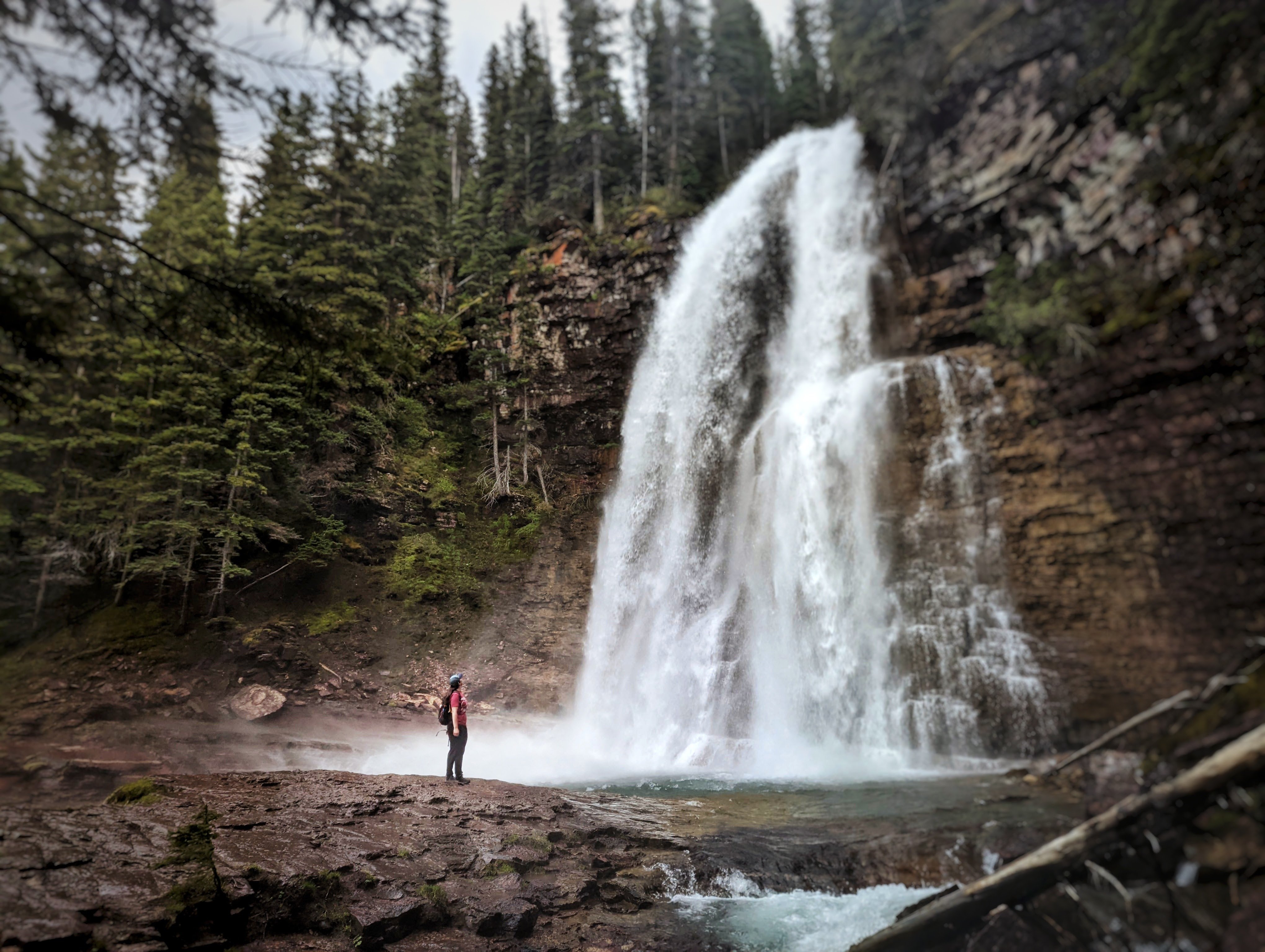 Rebekah in Glacier National Park looking at a waterfall