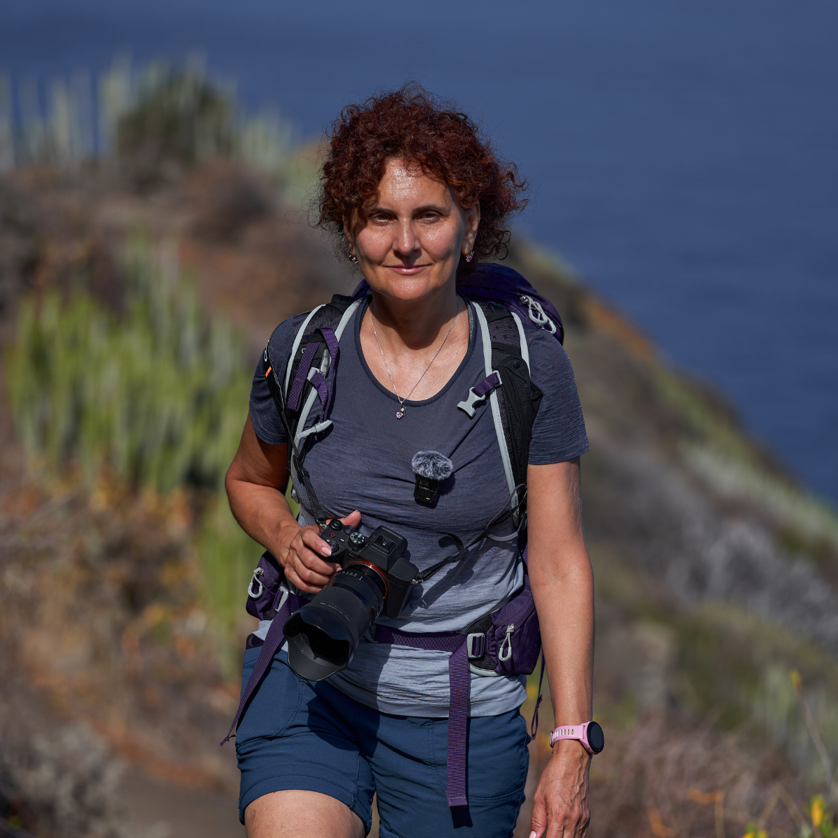 Woman hiking holding a camera