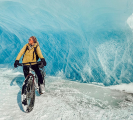 Woman riding a bicycle through a glacier