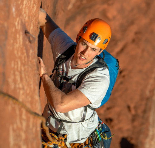 Man rock climbing up red rocks