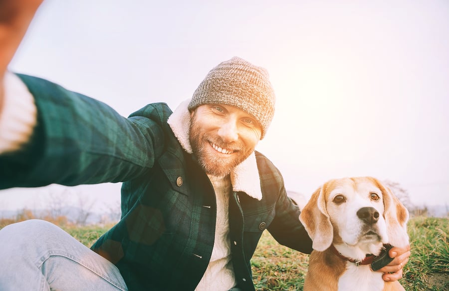 Man taking selfie with beagle dog