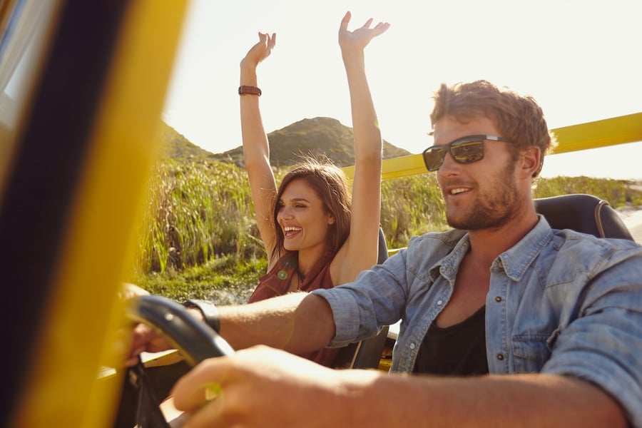 Man and woman driving in a convertible 