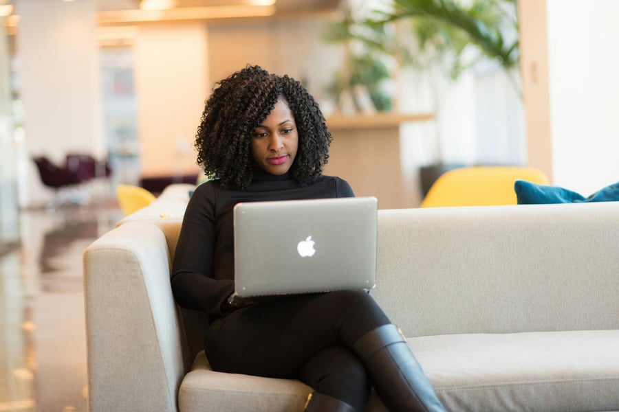 Woman sitting on a couch working on a laptop