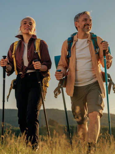 Couple with hiking poles in a field