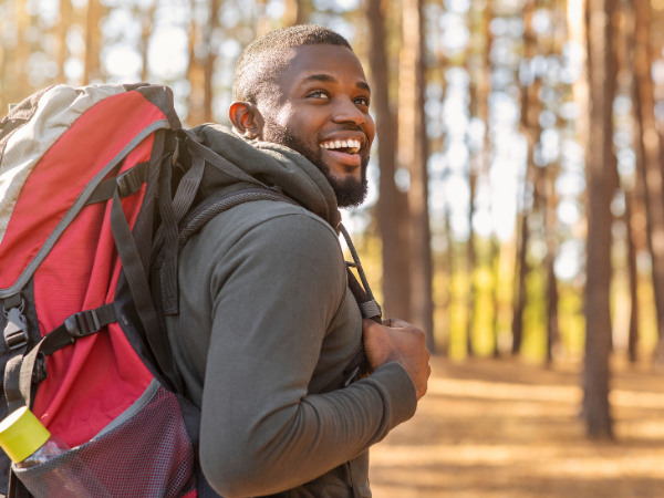 Man hiking through a forest with a backpack