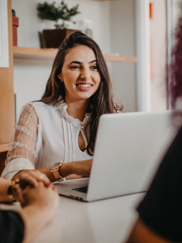 Woman sitting at a desk on her laptop speaking with a client
